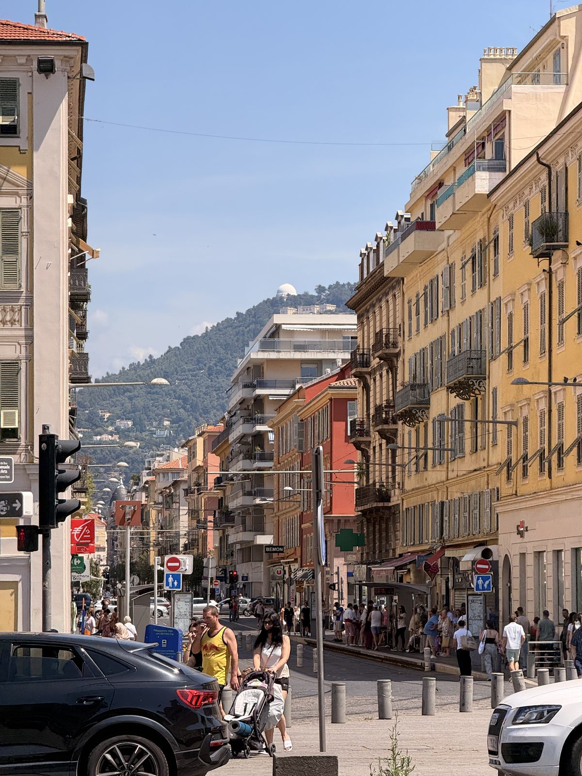 A street in Nice climbing towards the hills, cars and awnings in the afternoon light