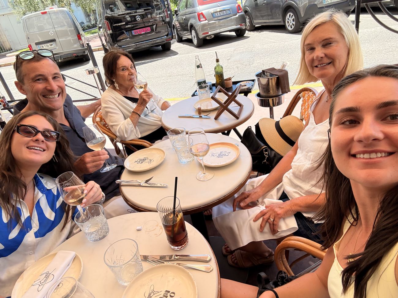 Six of the family crowded around a small café table in Cannes with drinks