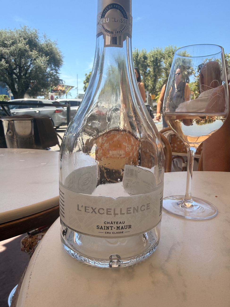 A bottle of Provence rosé and a glass on a sunlit table