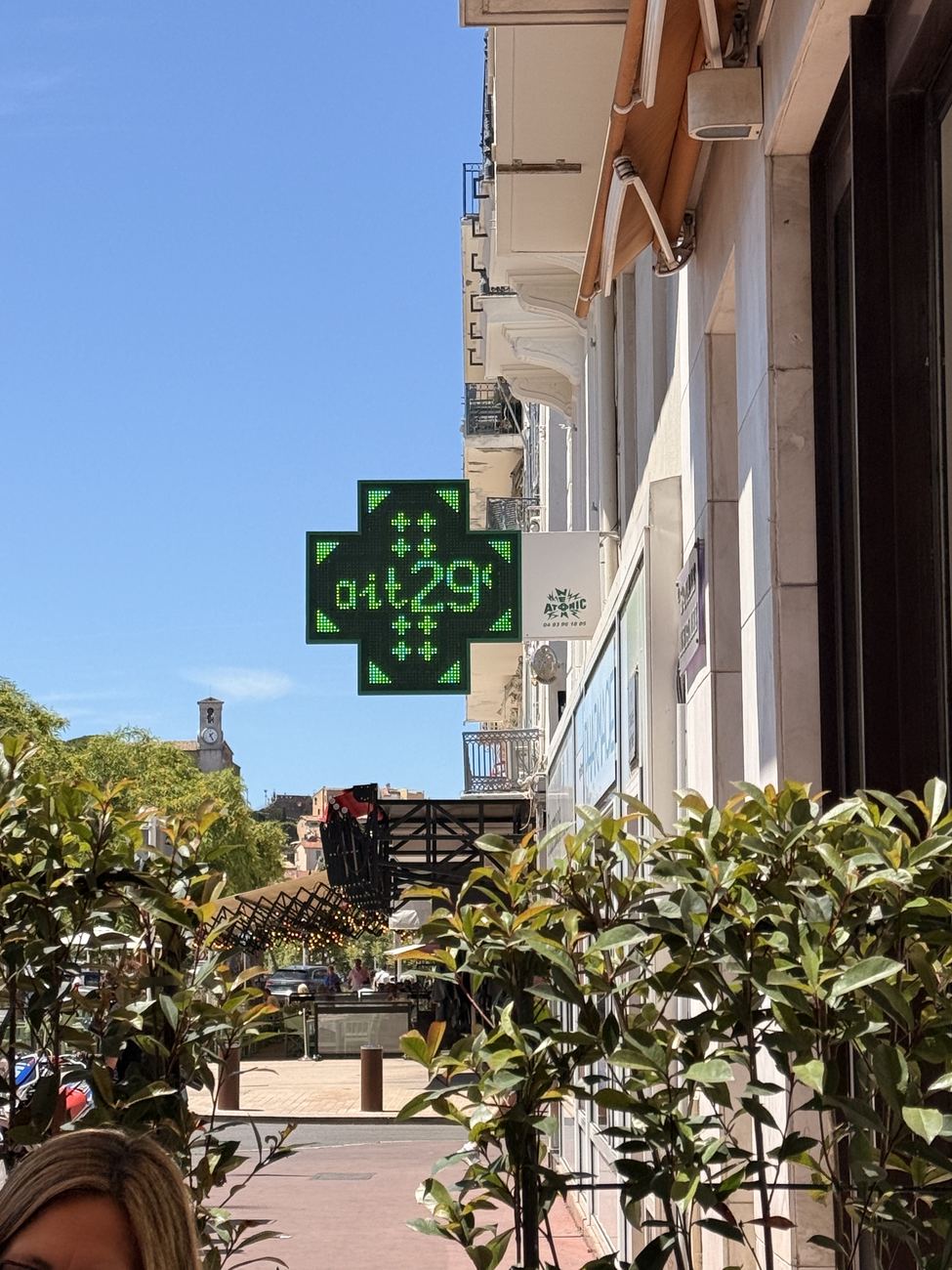 A green pharmacy cross in a Cannes street reading 29 degrees