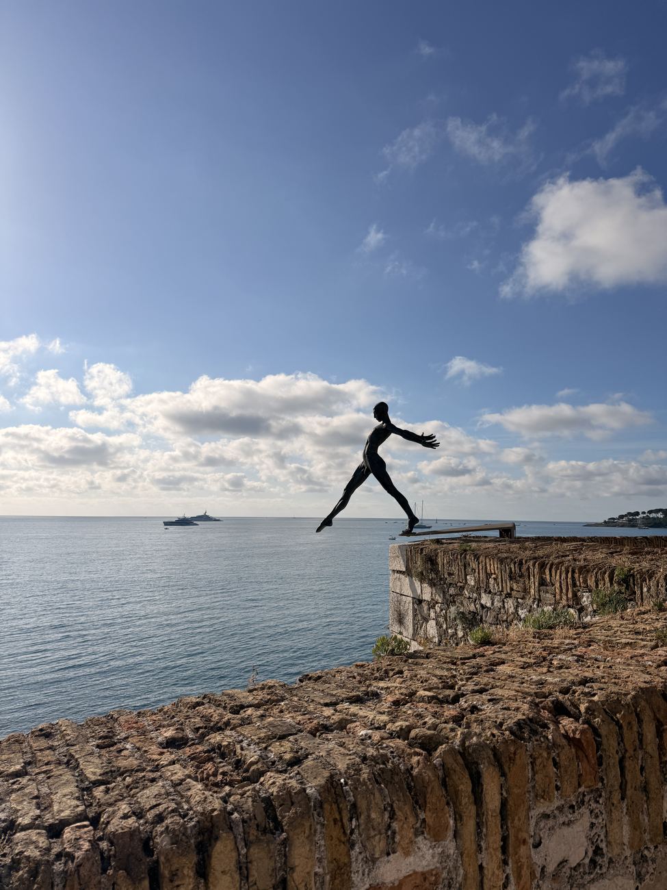 A figure leaping along the top of the sea wall at Antibes
