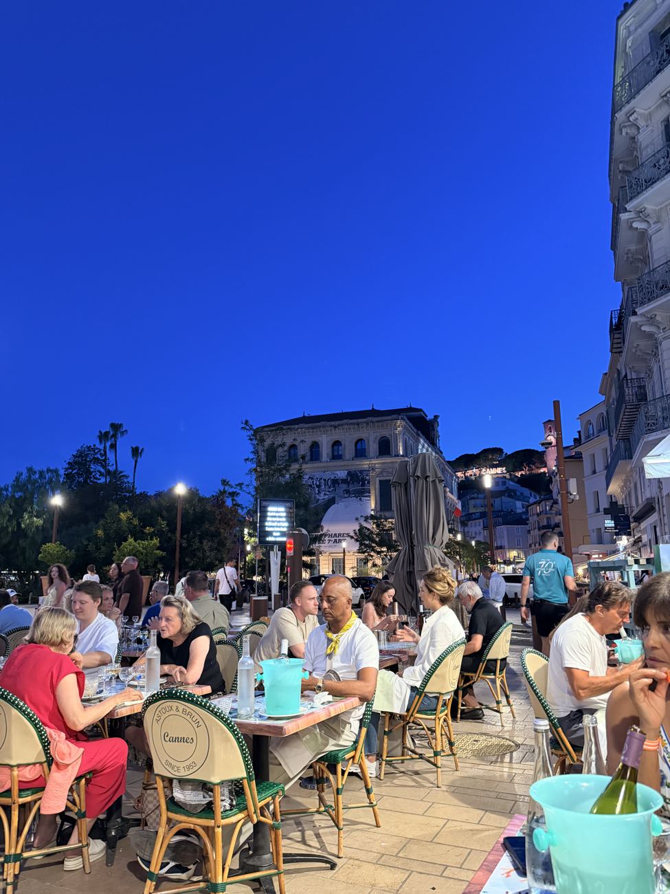 The evening crowd filling the terraces of Cannes, drinks and lamplight