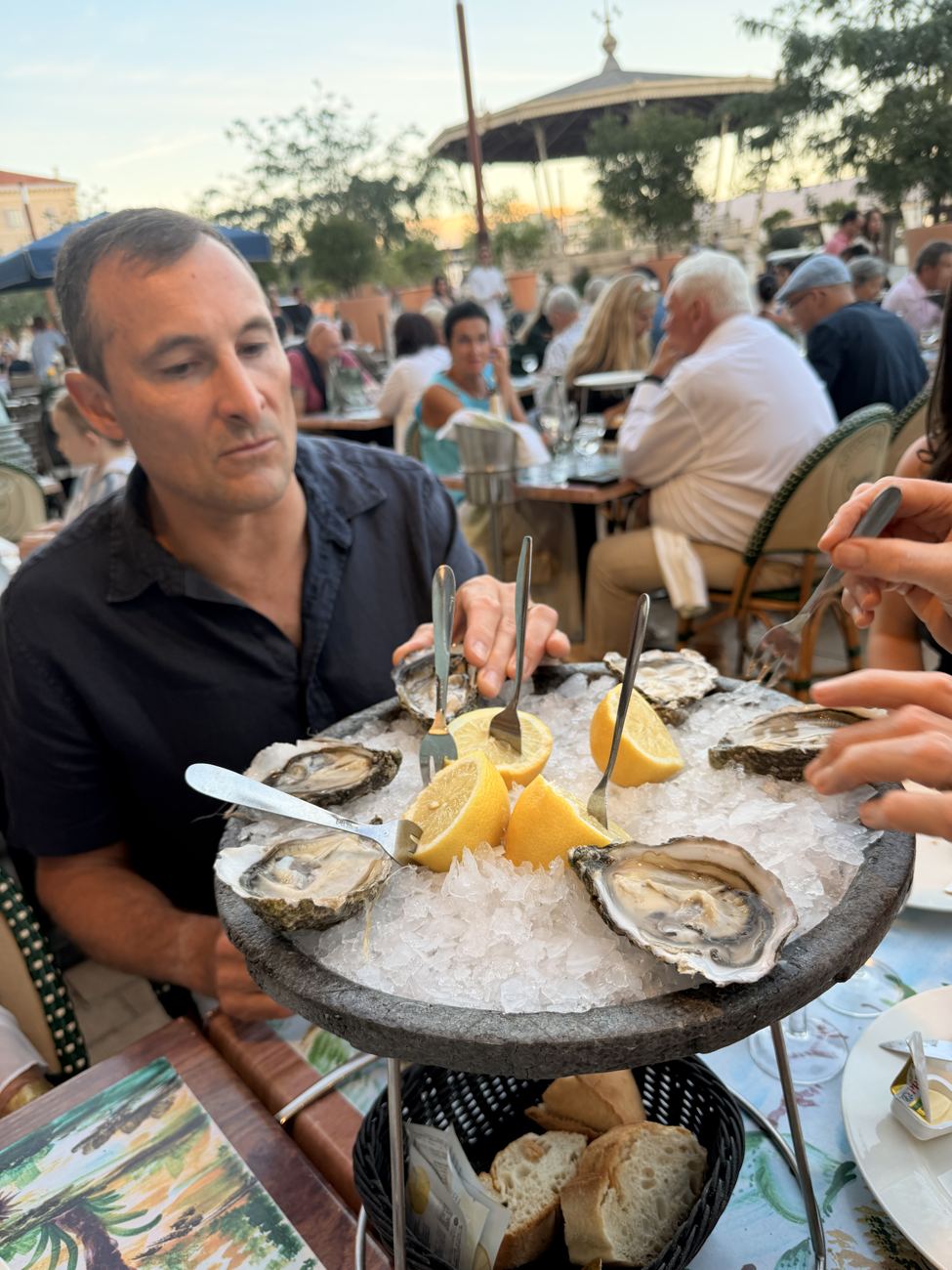 A man at the seafood table, the busy lamplit restaurant behind him