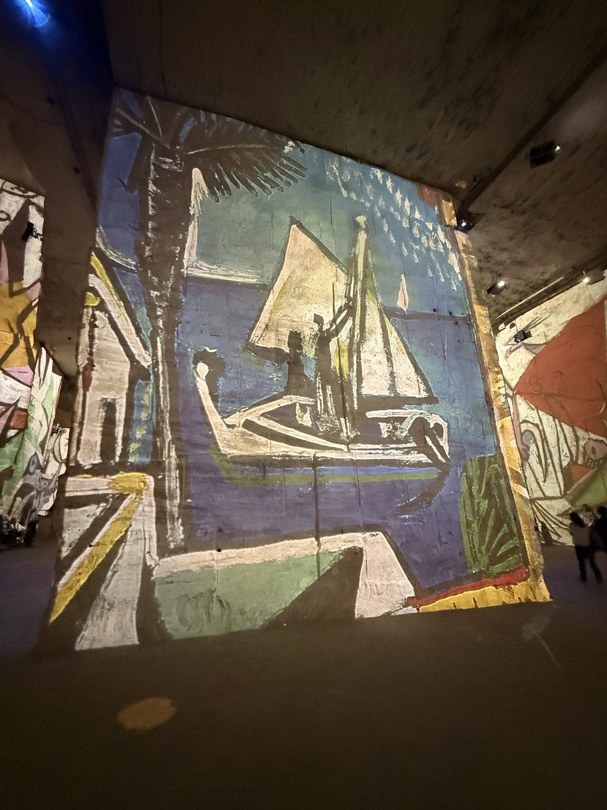 A projected Picasso boat and figures across the quarry stone