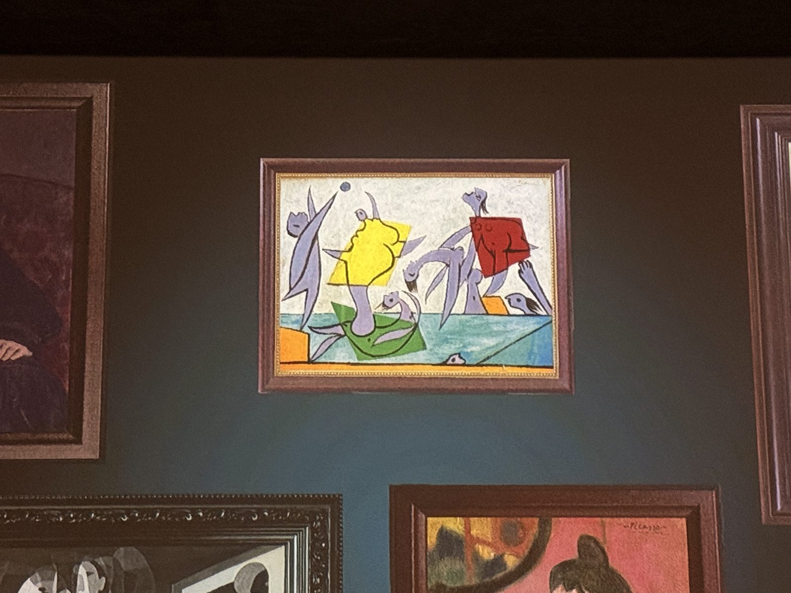 A framed Picasso painting hung conventionally on a dark gallery wall