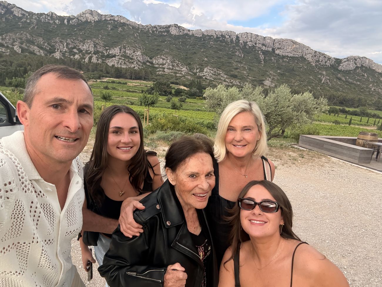 The family of five together in front of the Alpilles and vineyards at golden hour