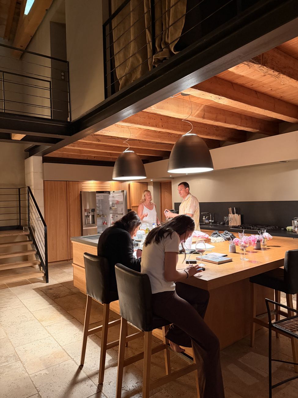 The family gathered at the kitchen island of the mas for the last supper, warm wood and low light