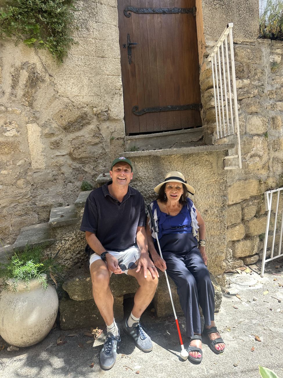 Two of the family resting on a stone bench in the shade