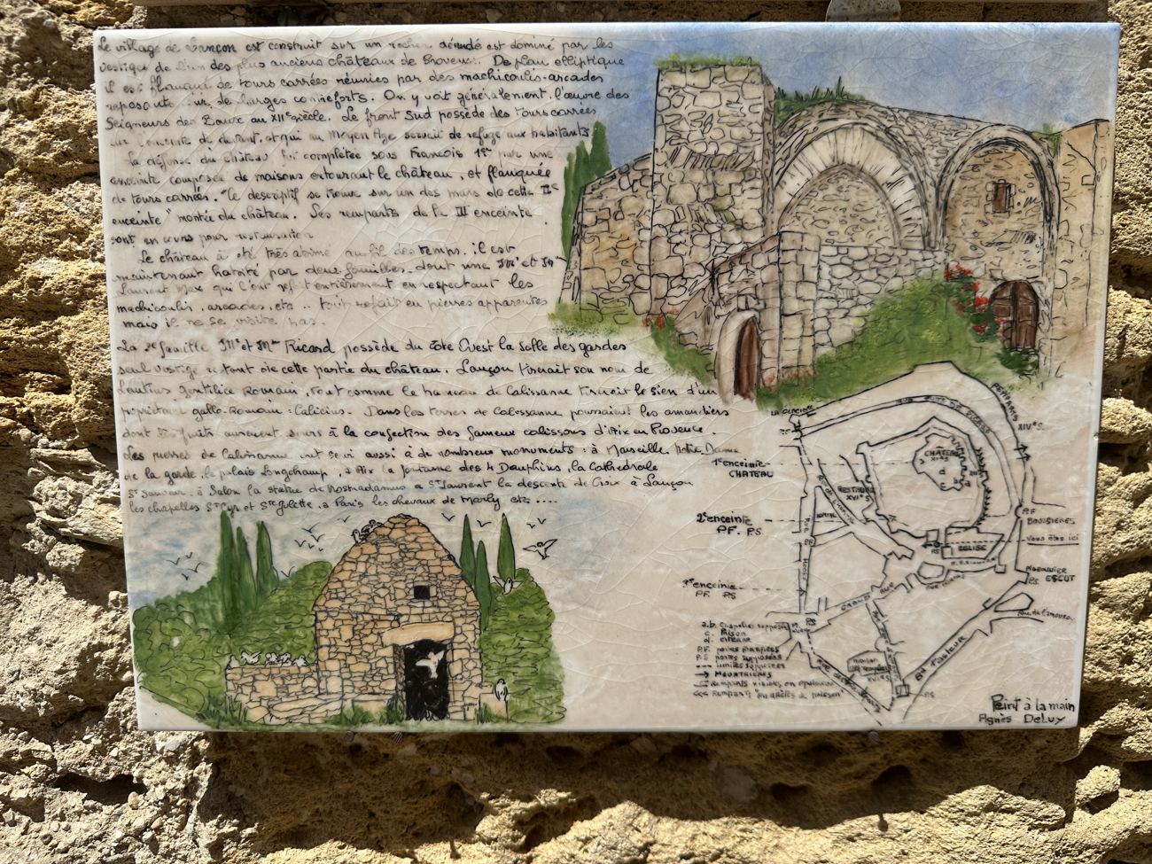 A painted panel showing the medieval château ruins and a map of the old fortified village