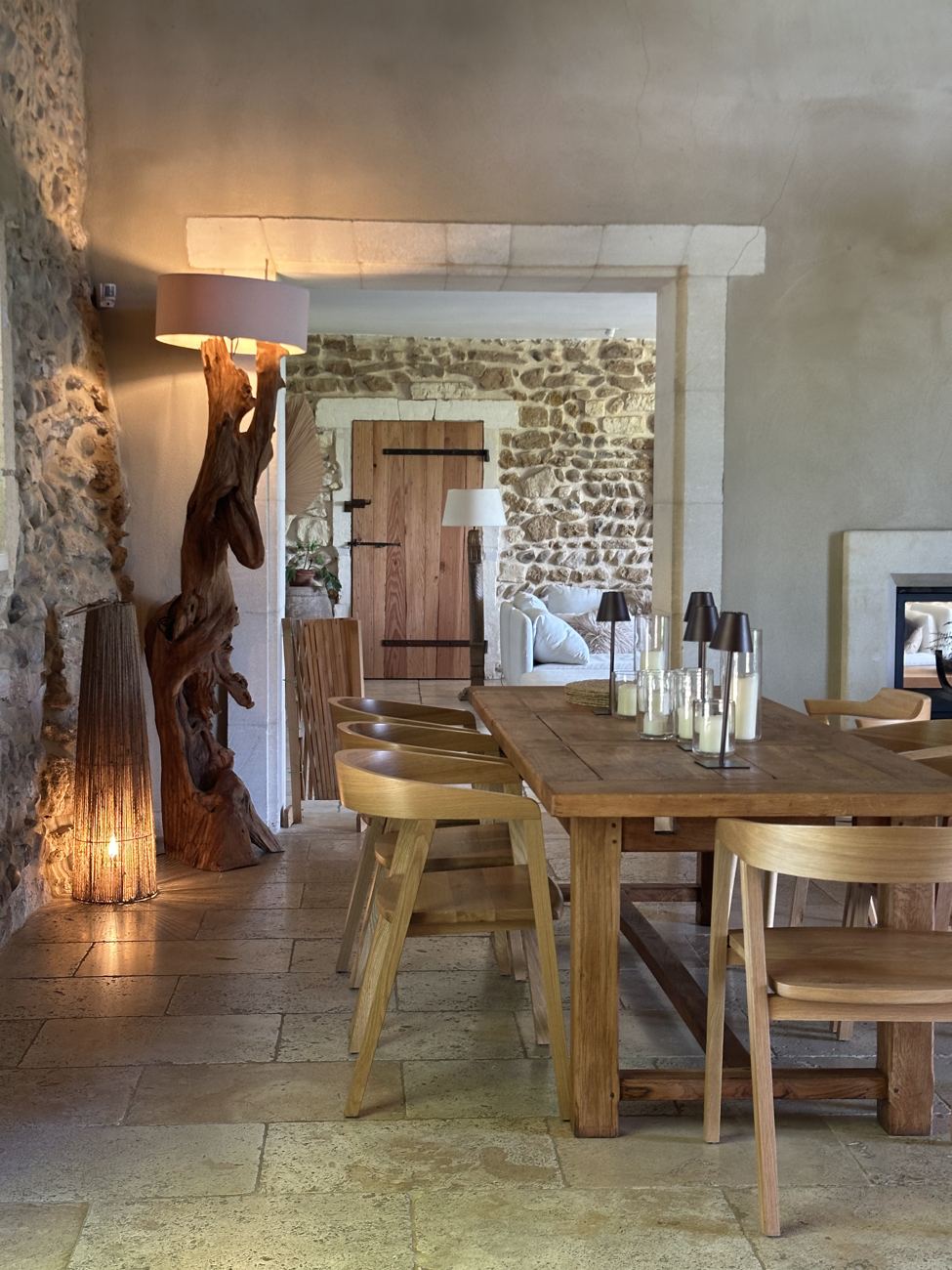 The cool interior of a wine cave — a long wooden table, bottles, stone walls