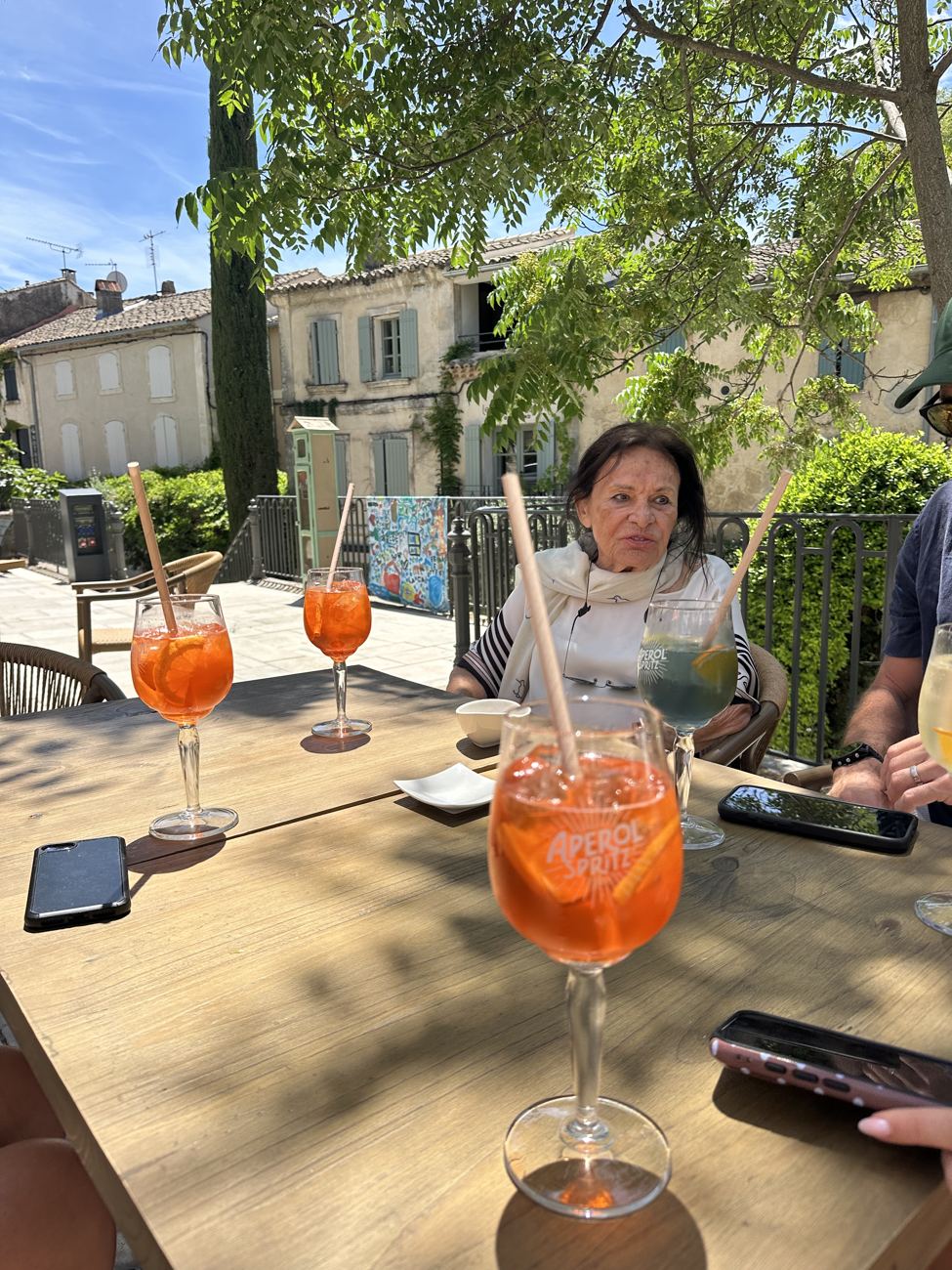 An Aperol spritz glowing orange on a sunlit café table
